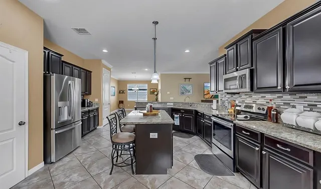 a view of a livingroom with a chandelier furniture and kitchen view