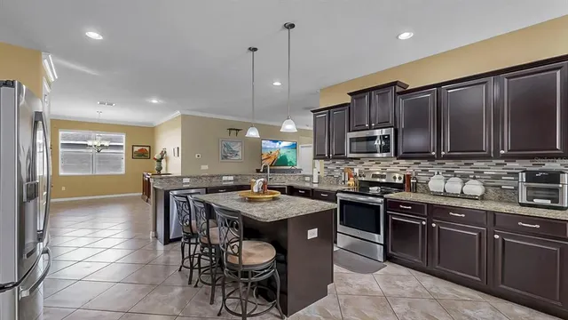 a kitchen with granite countertop a sink a counter top space and cabinets