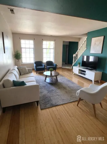a living room with furniture and a wooden floor