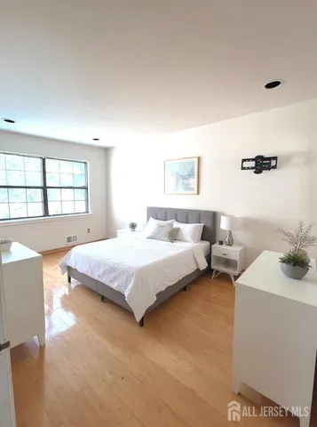 a spacious bedroom with a bed and a window