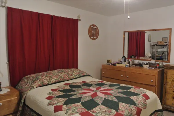 a bedroom with a bed and a dresser in it