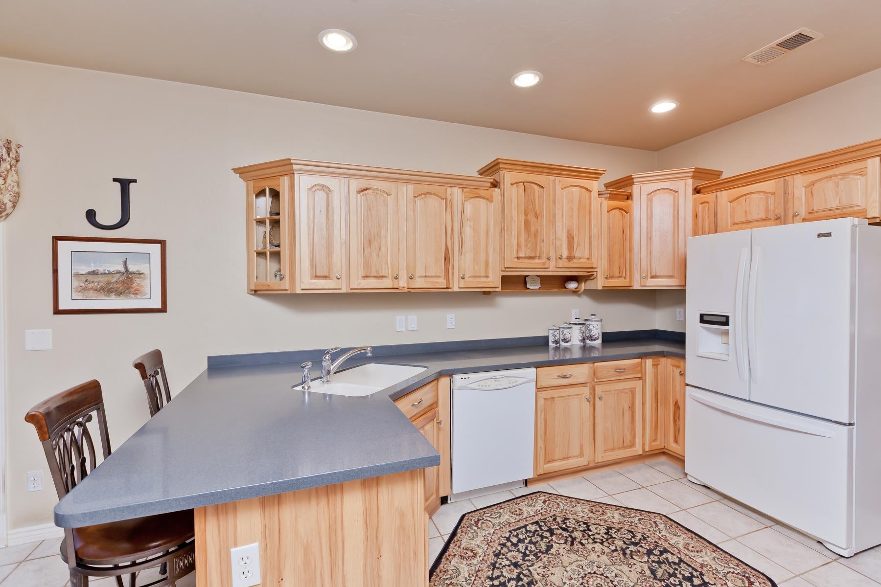 2912 El Torro Road Grand Junction, CO 81503 - Photo 11 of 34 a kitchen with stainless steel appliances granite countertop a refrigerator a sink a stove and white cabinets with wooden floor