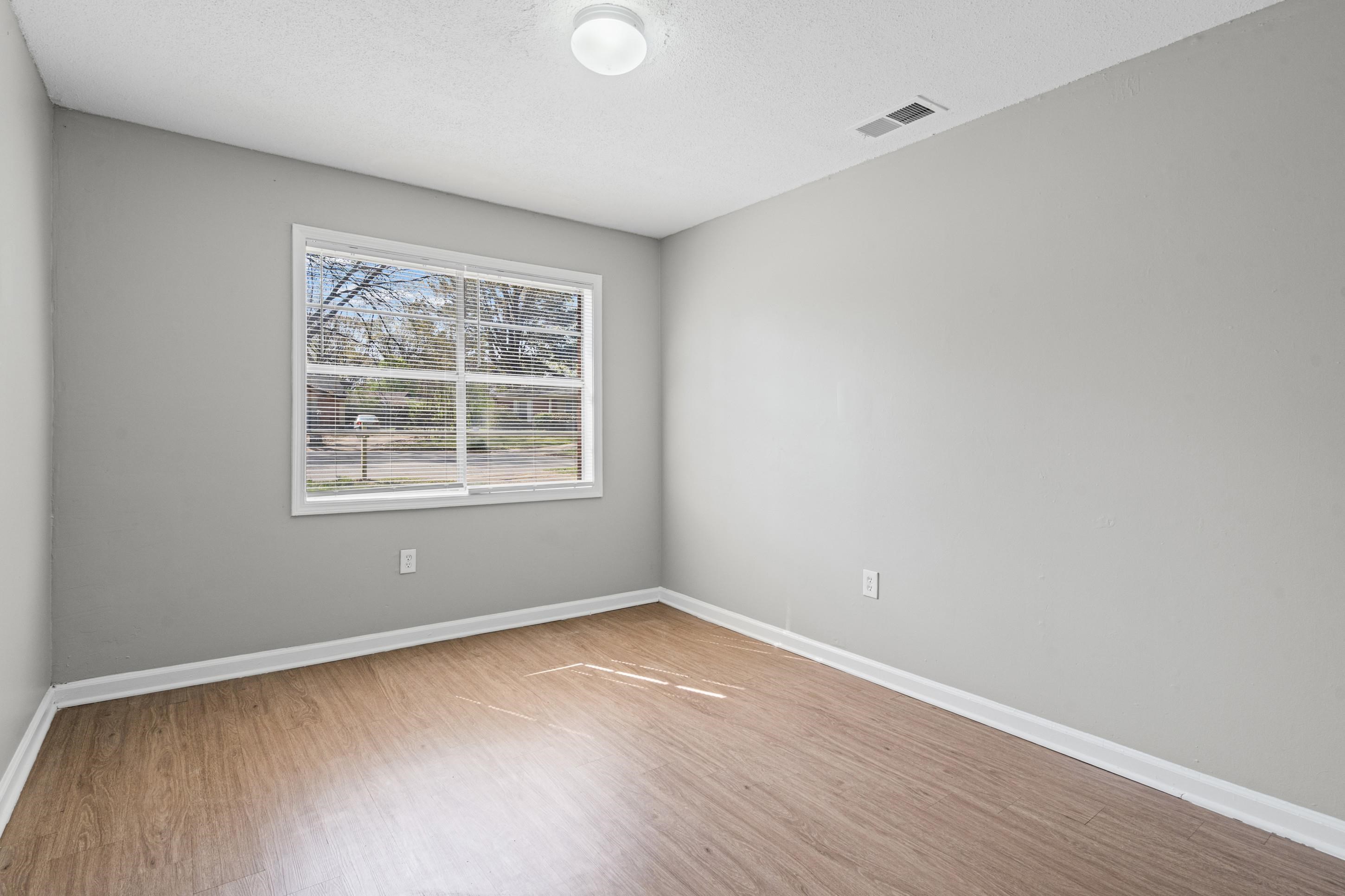 496 Greenview Cove Collierville, TN 38017 - Photo 14 of 24 an empty room with wooden floor and windows