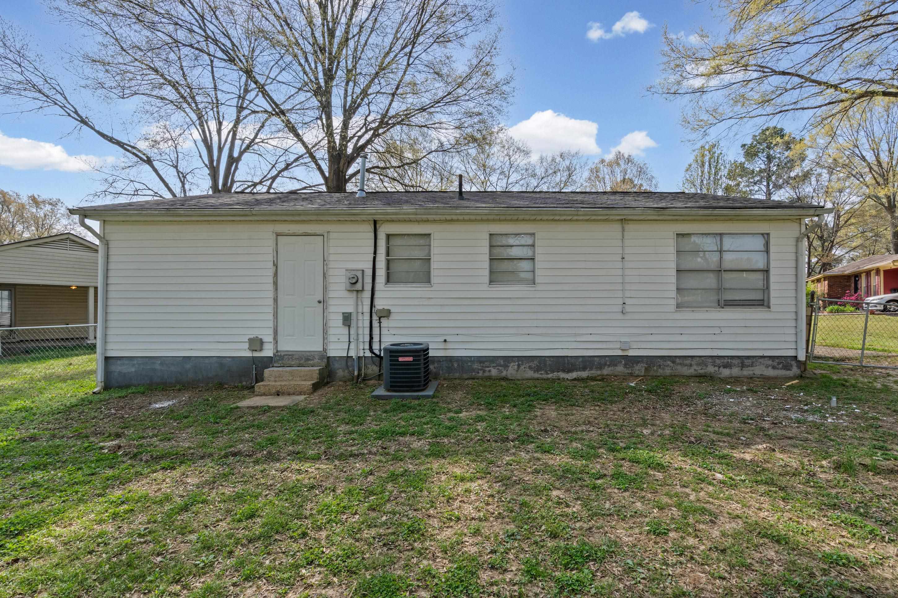 496 Greenview Cove Collierville, TN 38017 - Photo 18 of 24 a white house that has a small yard and a large tree