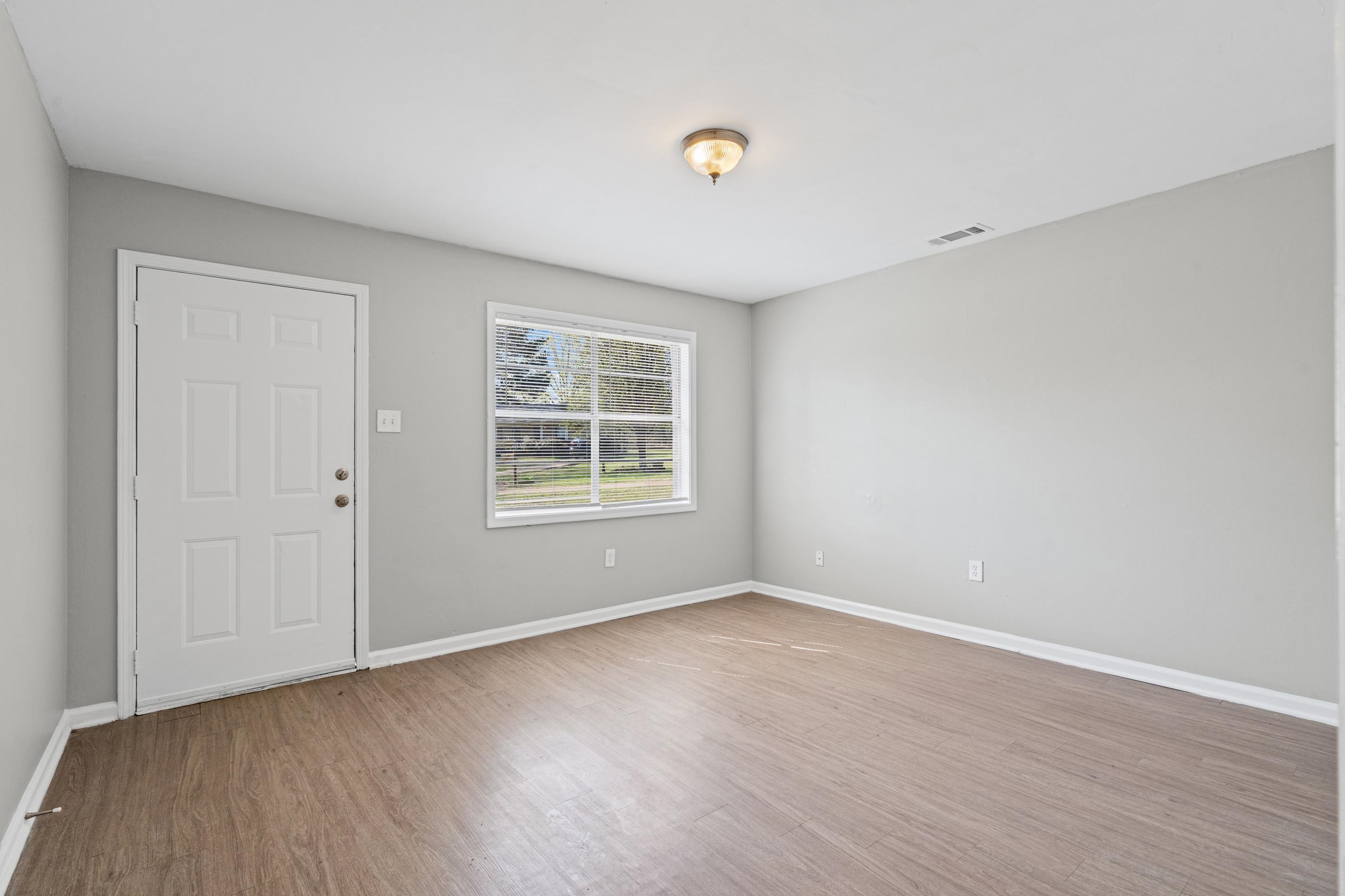 496 Greenview Cove Collierville, TN 38017 - Photo 5 of 24 an empty room with wooden floor and windows