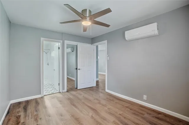 an empty room with wooden floor and ceiling fan