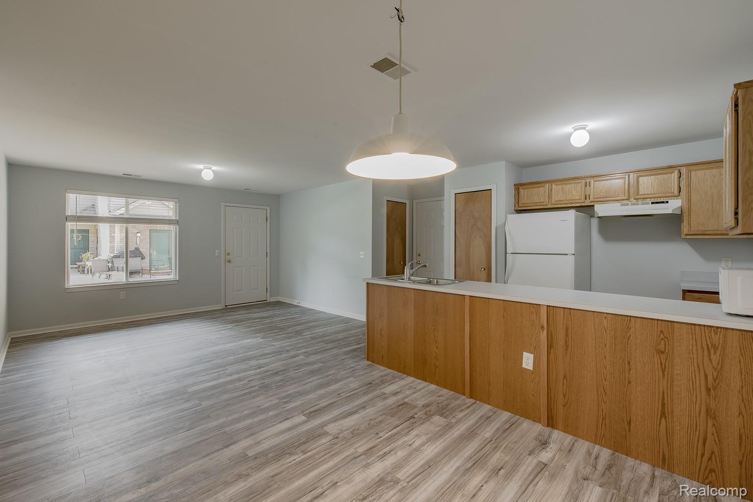 2154 Frazho Road Warren, MI 48091 - Photo 6 of 36 Open-concept living area featuring wood-finish flooring, a large window, and a white paneled door