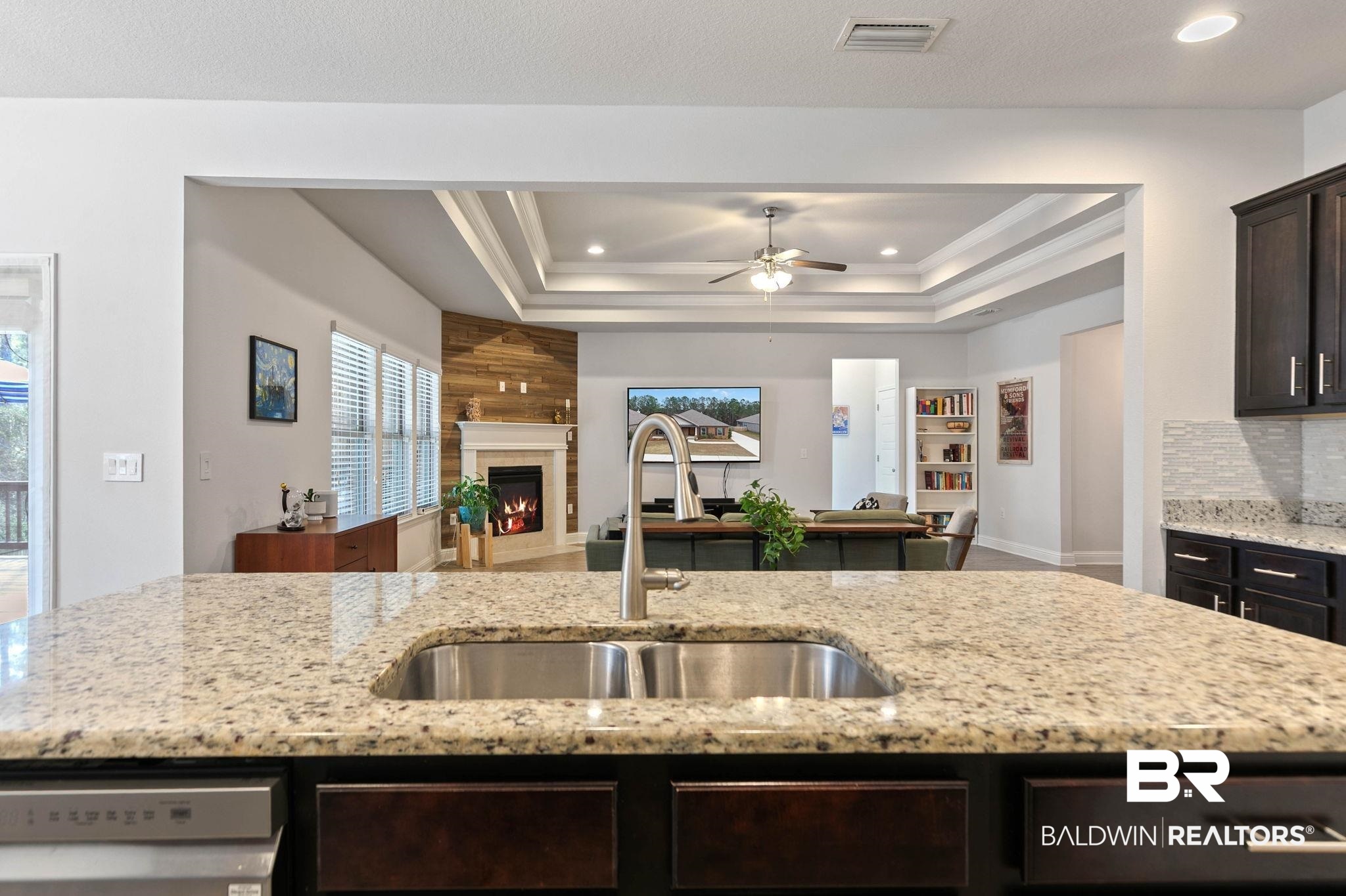 31350 Hoot Owl Road Daphne, AL 36527 - Photo 15 of 94 Kitchen featuring a ceiling fan, light stone countertops, dark wood finish cabinetry, a large fireplace, and dishwasher