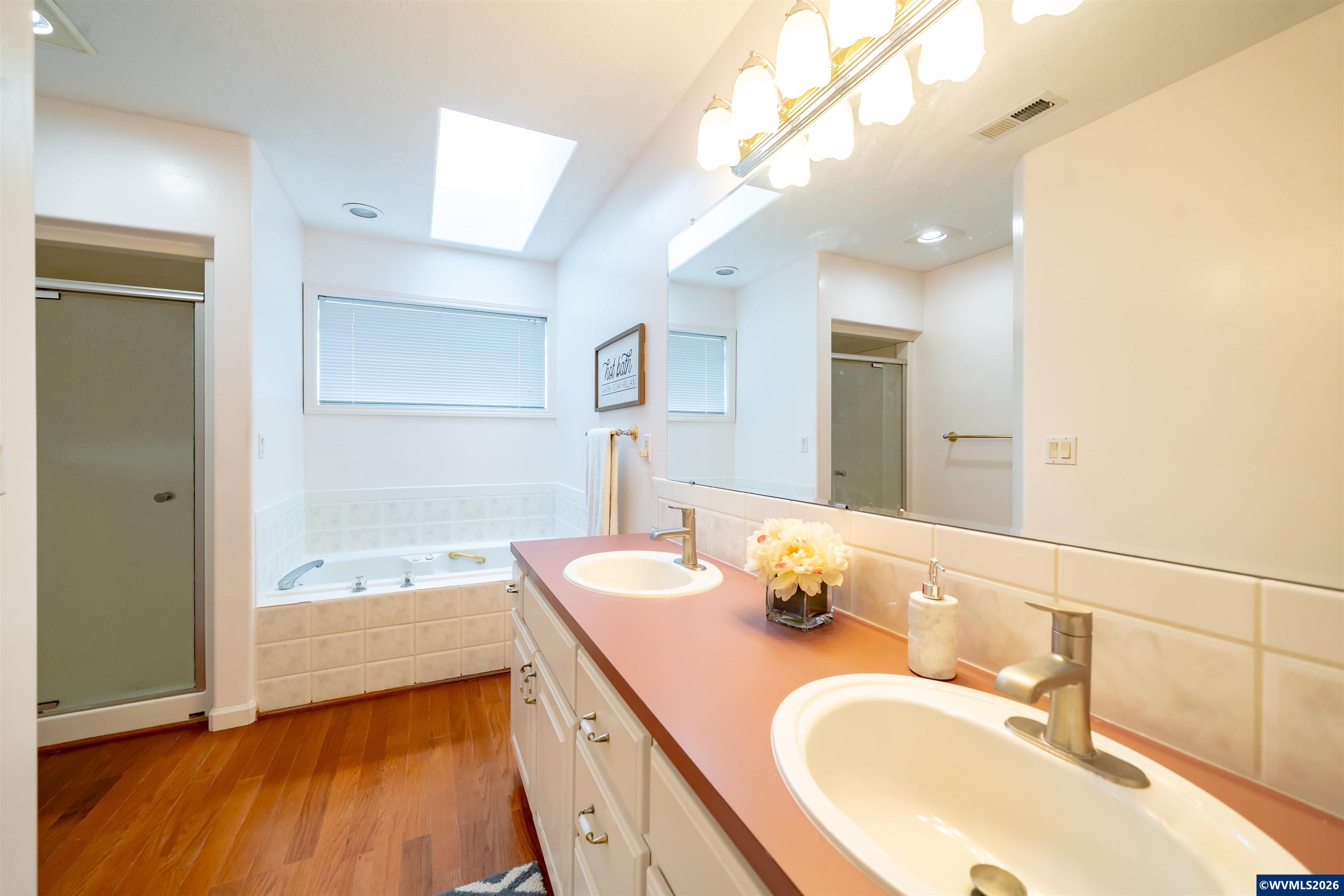 312 Southwest Cascade Meadow Drive Sublimity, OR 97385 - Photo 19 of 42 a bathroom with a granite countertop double vanity sink a mirror and bathtub