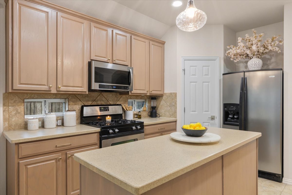 2501 Aspen Meadow Road Leander, TX 78641 - Photo 10 of 30 Kitchen featuring a central island, light-toned cabinetry, and stainless steel appliances