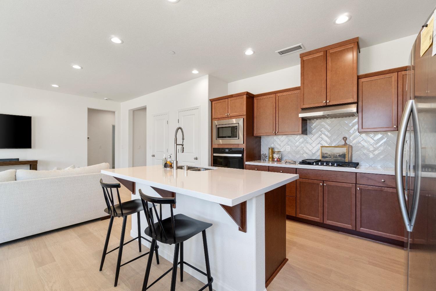 1241 Peters Road Madera, CA 93636 - Photo 14 of 37 a kitchen with stainless steel appliances granite countertop a sink a stove a refrigerator with a dining table and chairs