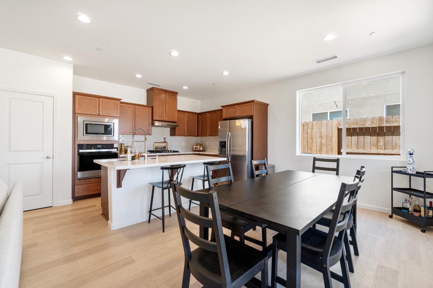 1241 Peters Road Madera, CA 93636 - Photo 15 of 37 a kitchen with stainless steel appliances kitchen island granite countertop a dining table and chairs