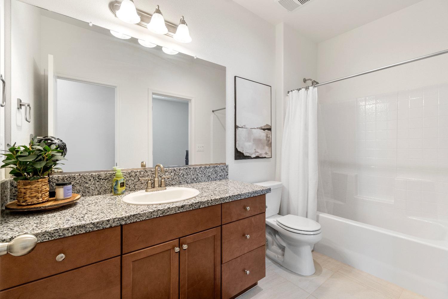 1241 Peters Road Madera, CA 93636 - Photo 24 of 37 a bathroom with a granite countertop sink a toilet and shower