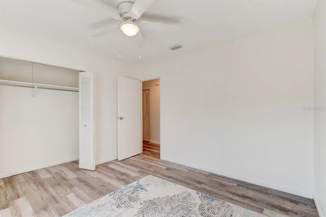an empty room with a ceiling fan and a window