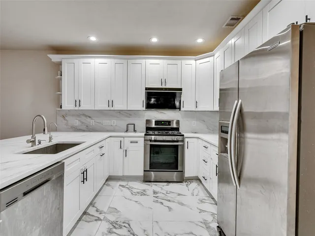 a kitchen with stainless steel appliances kitchen island granite countertop a sink and cabinets