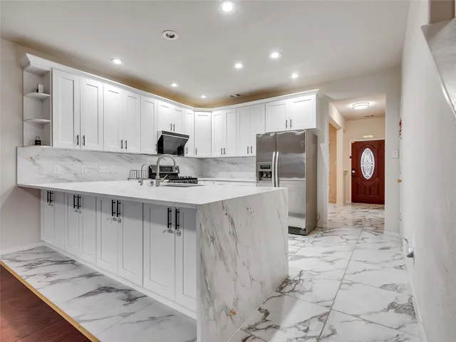 a view of kitchen with wooden floor and electronic appliances