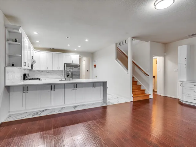 a view of a kitchen with wooden floor and staircase
