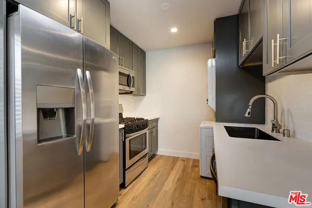 a kitchen with stainless steel appliances granite countertop a refrigerator and a sink