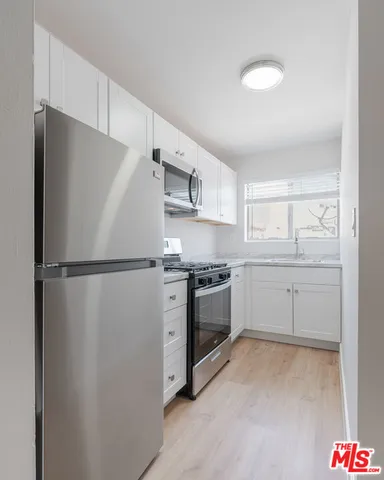a kitchen with stainless steel appliances a refrigerator sink and cabinets