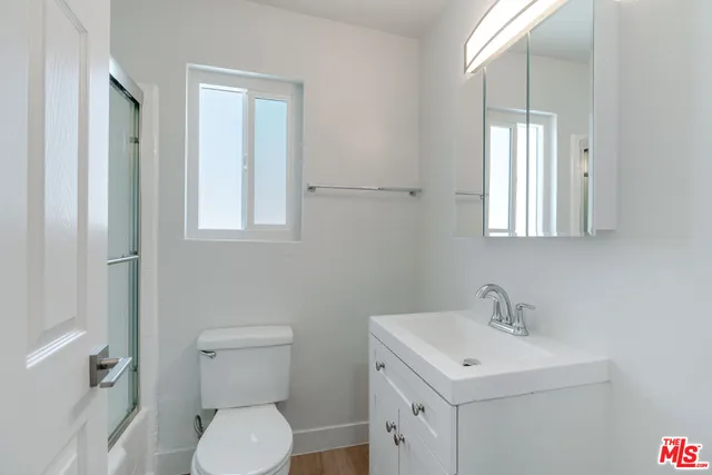 a bathroom with a toilet a sink and mirror