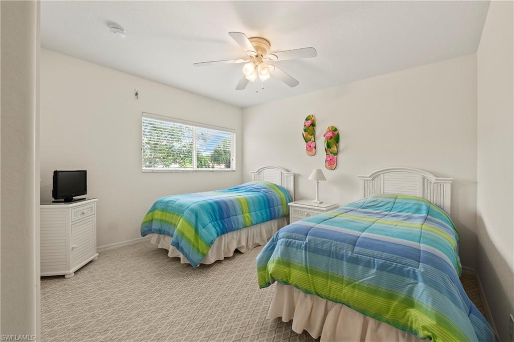 17887 Modena Road Miromar Lakes, FL 33913 - Photo 24 of 50 a bedroom with two beds and a chandelier