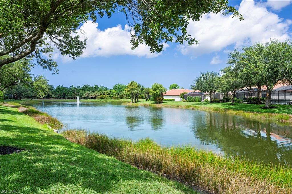 17887 Modena Road Miromar Lakes, FL 33913 - Photo 30 of 50 a view of a lake with a house in the background