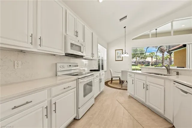 a kitchen with white cabinets and white appliances