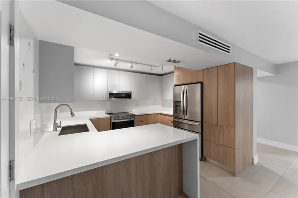 a kitchen with a refrigerator and a sink