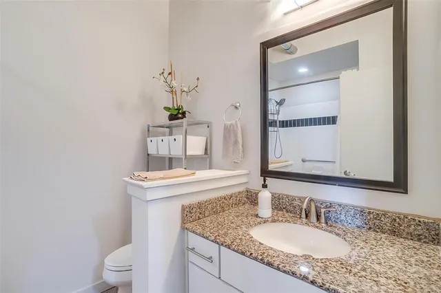 a bathroom with a granite countertop sink and a mirror