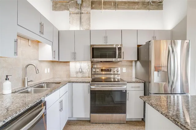 a bathroom with a granite countertop sink and large mirror