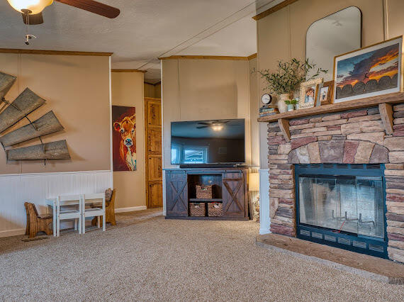 6341 Farm Private Road Levelland, TX 79336 - Photo 13 of 46 a living room with furniture a flat screen tv and a fireplace