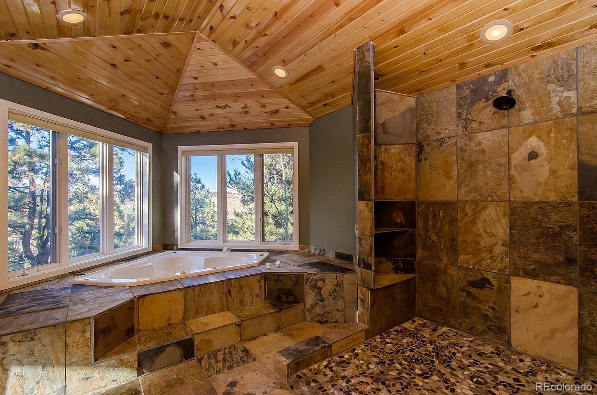 955 Castle Ridge Road Golden, CO 80401 - Photo 12 of 27 a spacious bathroom with a tub and a shower