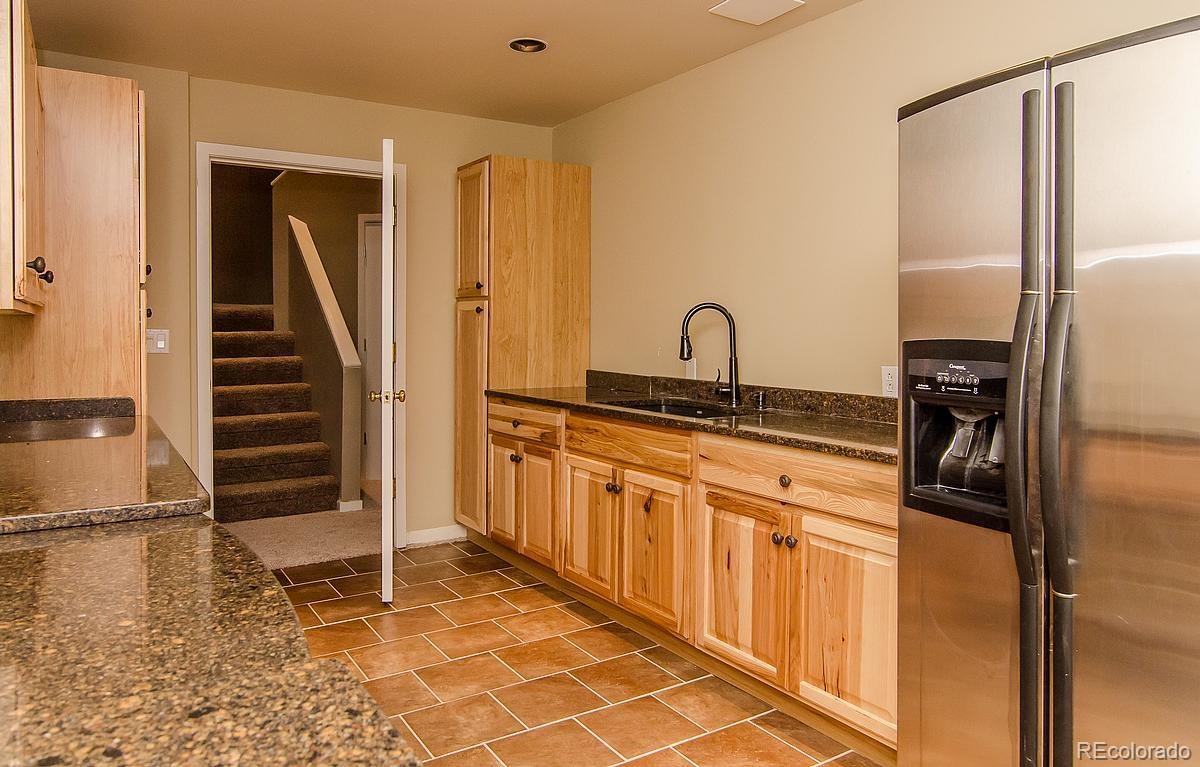 955 Castle Ridge Road Golden, CO 80401 - Photo 21 of 27 a kitchen with granite countertop a refrigerator and a sink