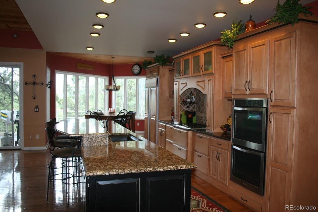 955 Castle Ridge Road Golden, CO 80401 - Photo 6 of 27 a kitchen with kitchen island granite countertop a sink stove and refrigerator