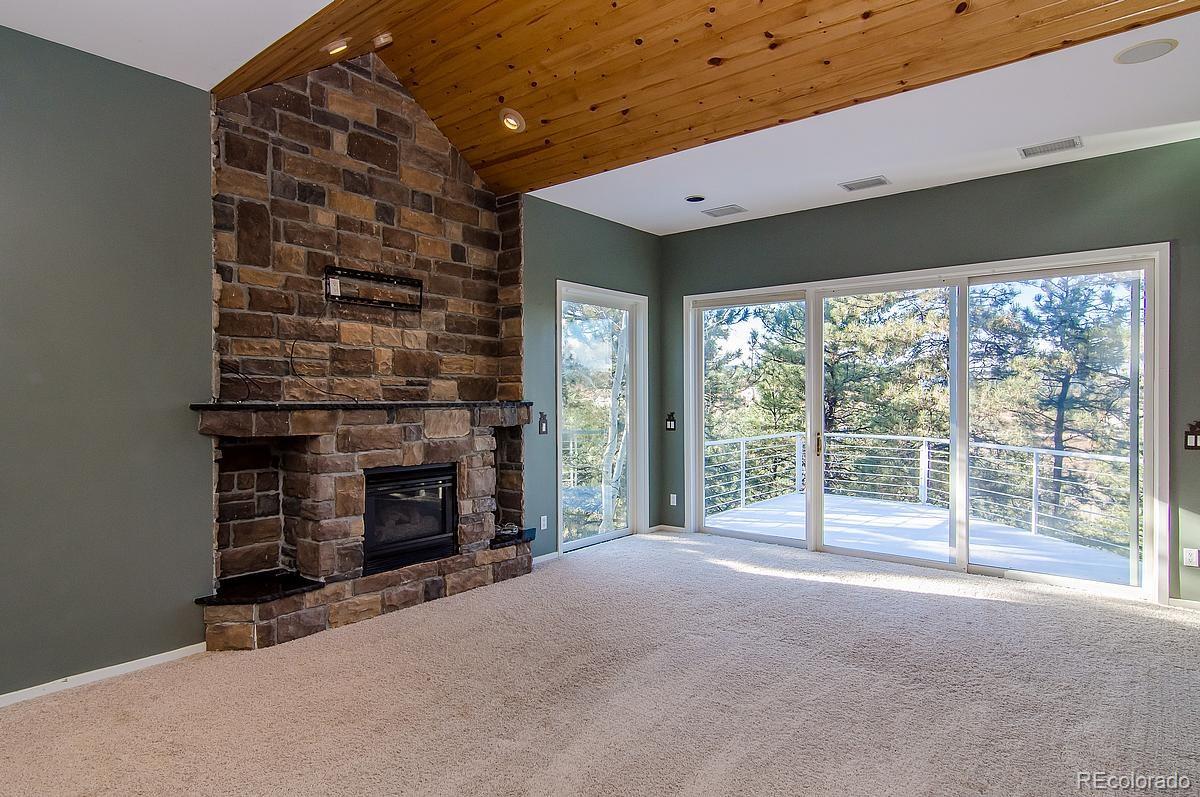 955 Castle Ridge Road Golden, CO 80401 - Photo 10 of 27 a view of an empty room with a fireplace and a window