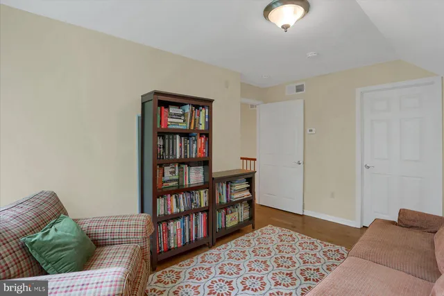 a white kitchen sink with potted plants next to a window