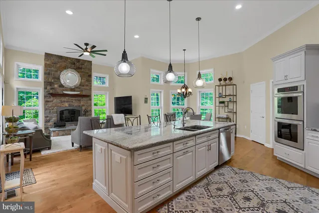 a living room with furniture a flat screen tv and a fireplace with a large window
