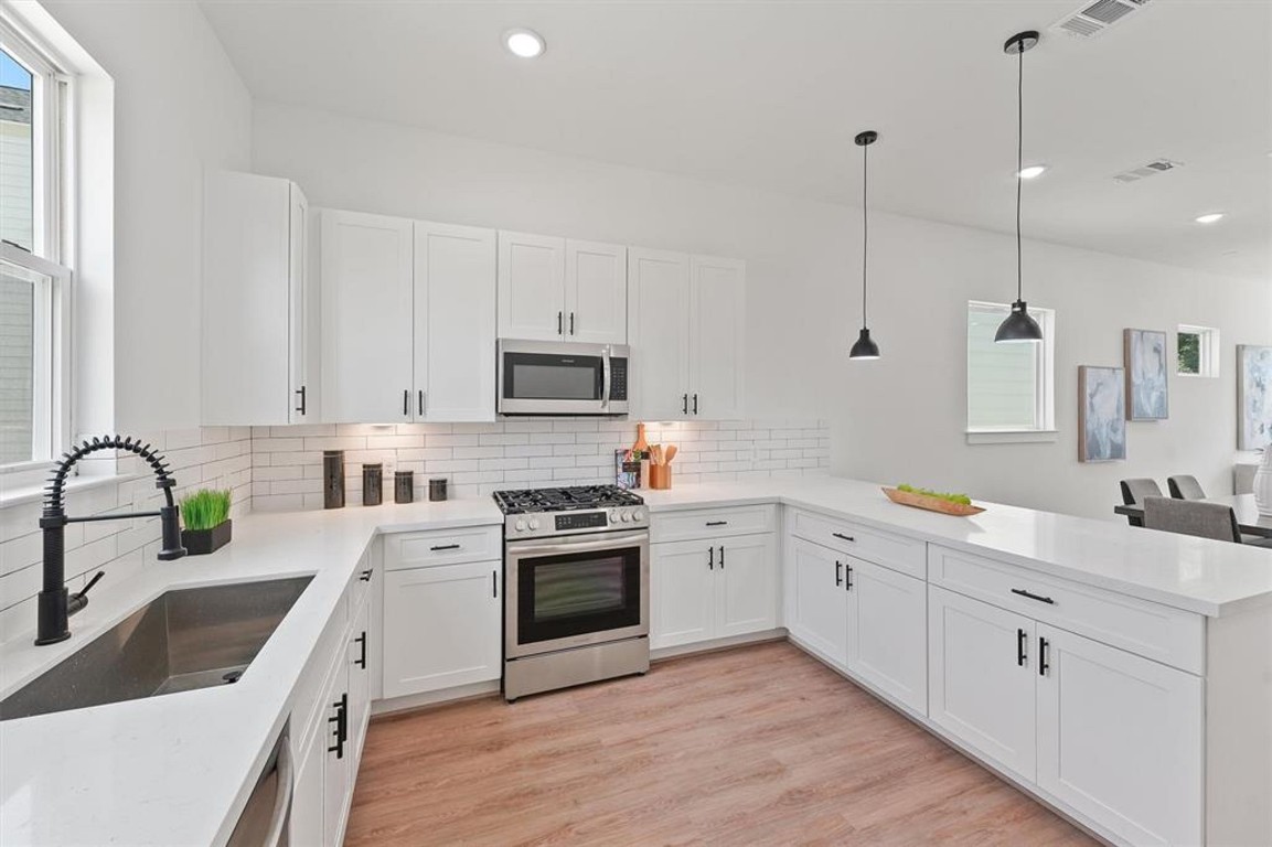 1207 Cavalcade Street, Unit B Houston, TX 77009 - Photo 11 of 20 a kitchen with white cabinets appliances and a sink