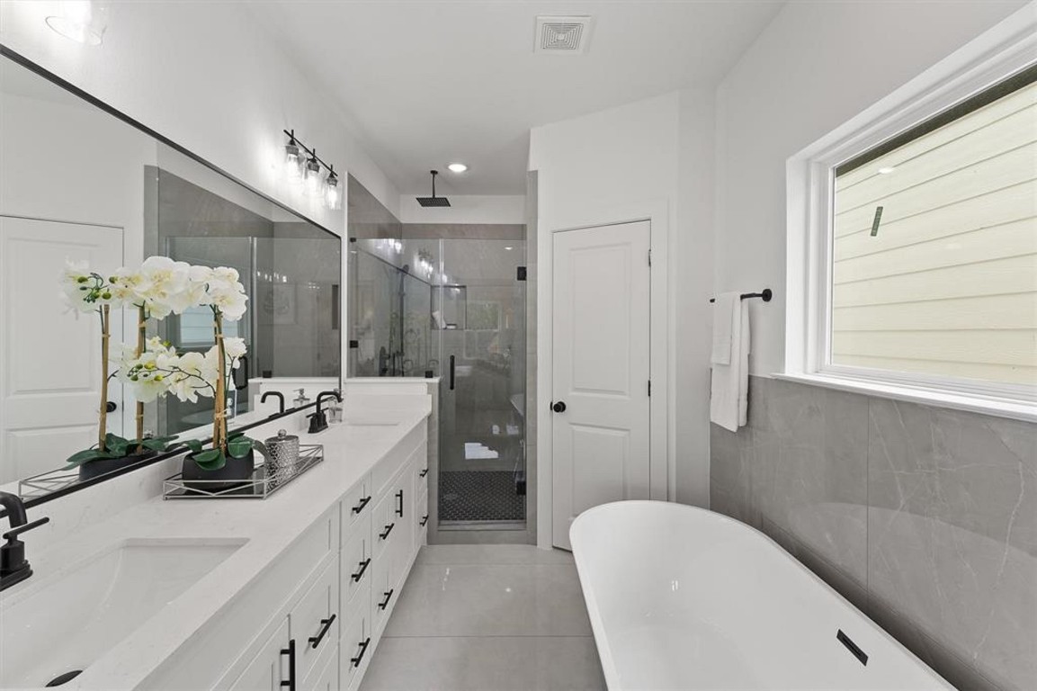 1207 Cavalcade Street, Unit B Houston, TX 77009 - Photo 15 of 20 a spacious bathroom with double vanity sinks a large mirror and a shower