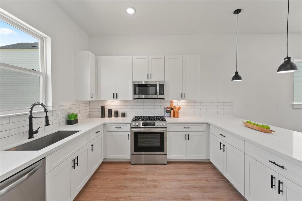 1207 Cavalcade Street, Unit B Houston, TX 77009 - Photo 9 of 20 a kitchen with white cabinets appliances and a sink