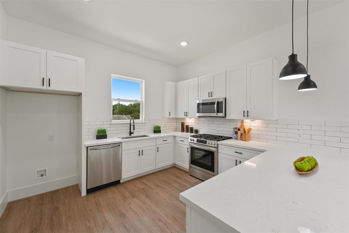 1207 Cavalcade Street, Unit B Houston, TX 77009 - Photo 10 of 20 a kitchen with sink a stove and chairs with wooden floor