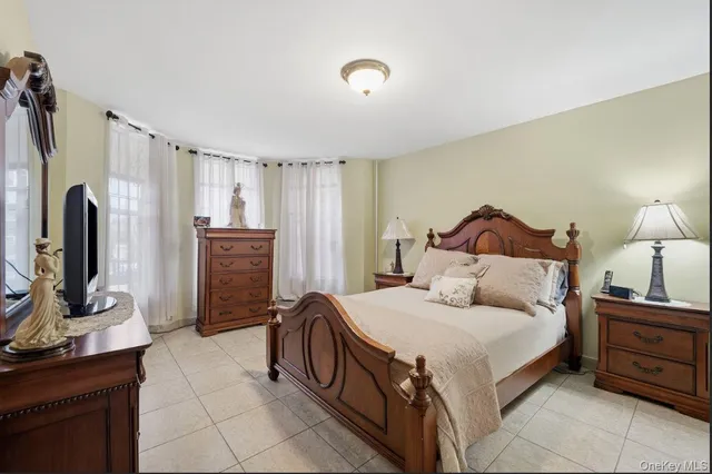 a bedroom with a bed and a flat screen tv on dresser