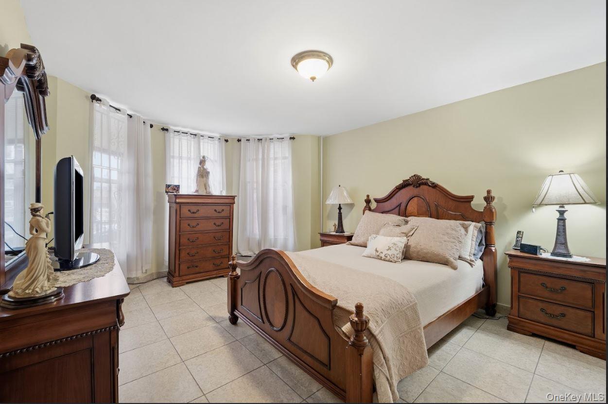 20-15 Menahan Street Queens, NY 11385 - Photo 14 of 41 a spacious bedroom with a bed and a flat screen tv