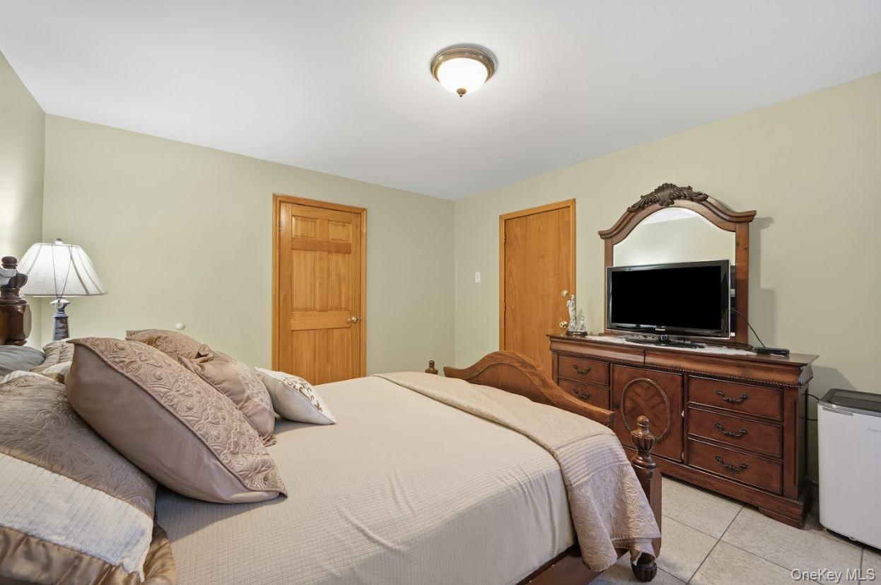 20-15 Menahan Street Queens, NY 11385 - Photo 15 of 41 a bedroom with a bed and a flat screen tv on dresser