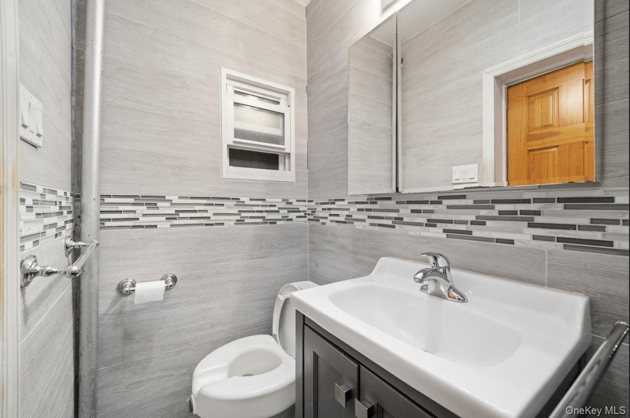 20-15 Menahan Street Queens, NY 11385 - Photo 19 of 41 a bathroom with a sink a toilet and mirror