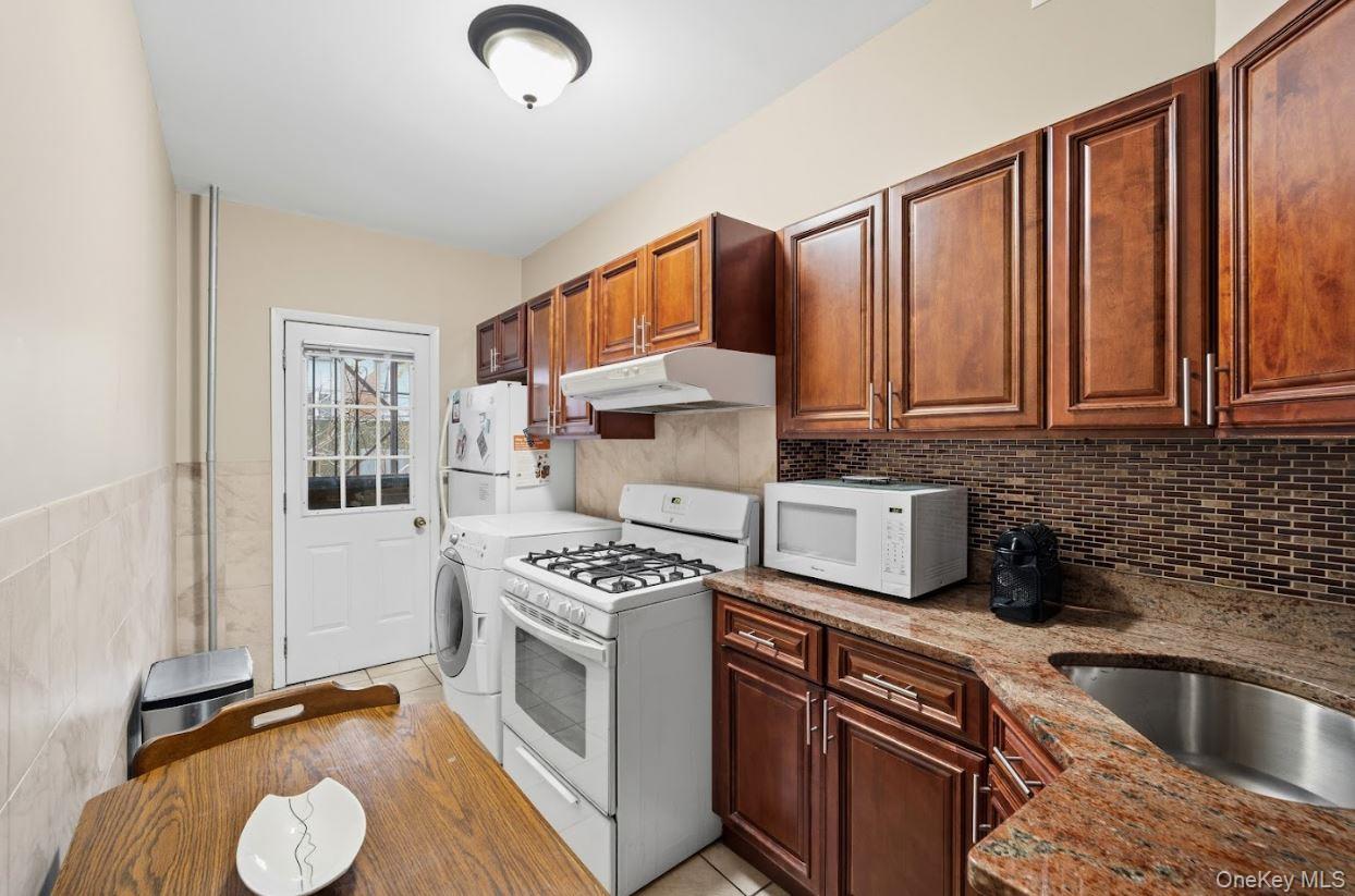 20-15 Menahan Street Queens, NY 11385 - Photo 8 of 41 a kitchen with stainless steel appliances granite countertop a sink stove and cabinets