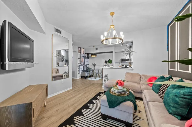 a living room with hard wood floor furniture and a chandelier