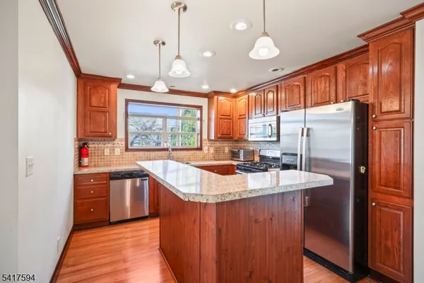 a kitchen with stainless steel appliances granite countertop a sink a stove and a refrigerator