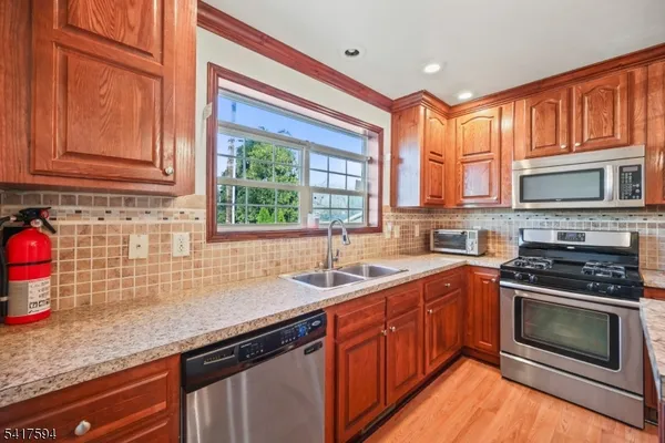a kitchen with granite countertop a sink stove and cabinets