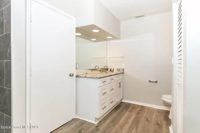 a bathroom with a granite countertop sink and a mirror
